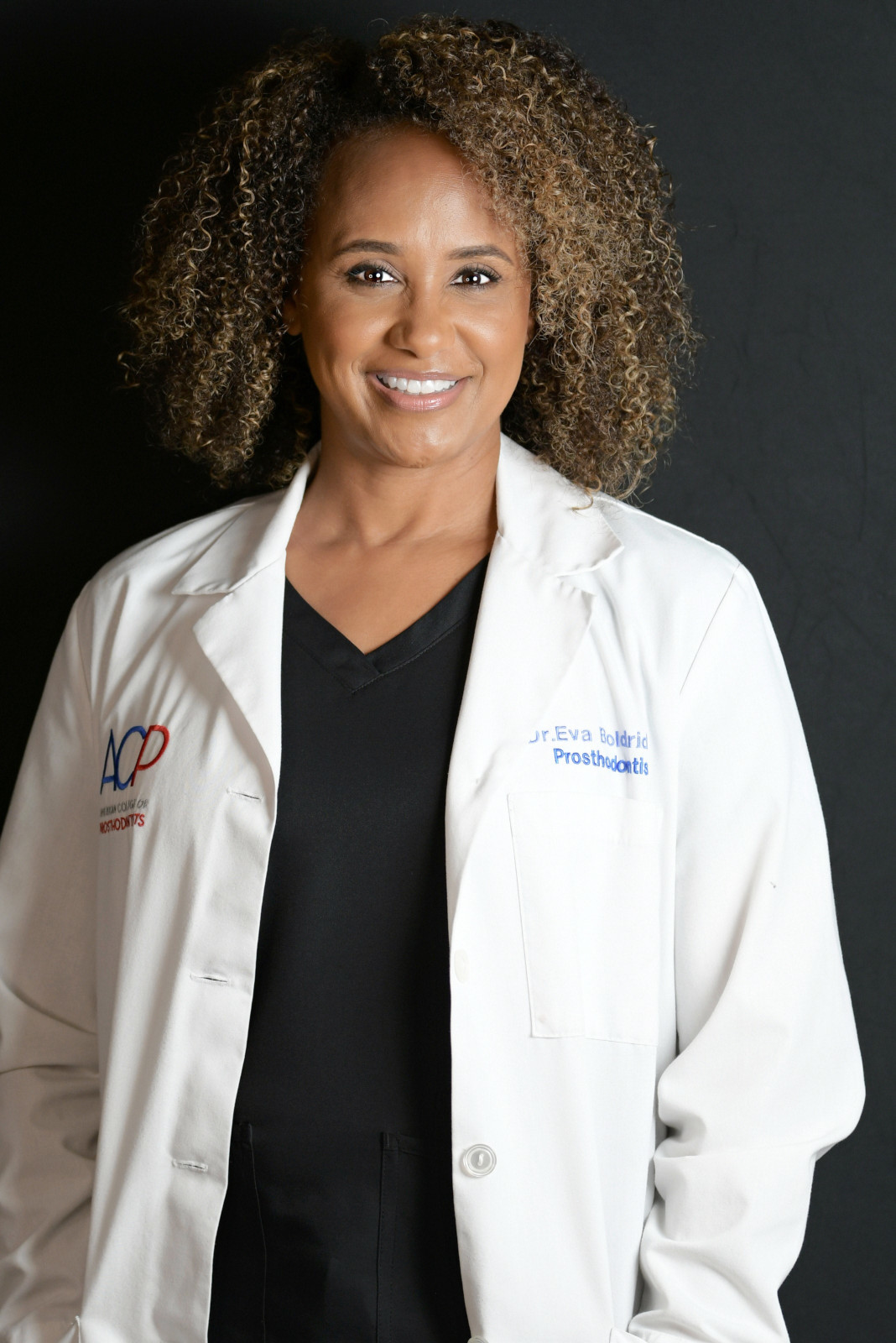 Dr. Eva Boldridge standing in white coat with the prosthodontist